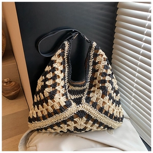 Detail view of the handmade woven beach bag with geometric patterns and leather strap