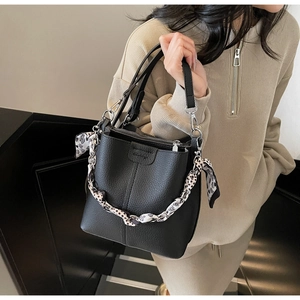 Detailed view of black lychee grain bucket bag with silk scarf and silver zipper