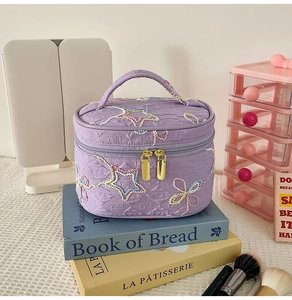 Lila gesteppte Kosmetiktasche mit farbigen Sternstickereien und Goldreißverschluss