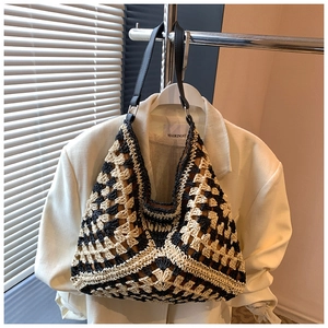 Detail of black and white hollow crochet tote bag with geometric pattern and leather strap