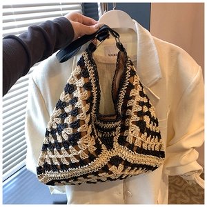 Detail of hand-woven crochet beach bag featuring geometric patterns and leather handles