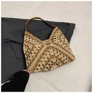 Detailed close-up of woven geometric texture and brown faux leather shoulder strap