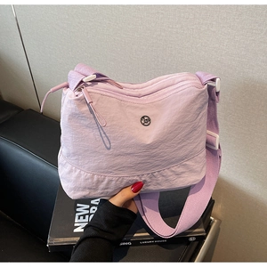 Detail of light purple nylon crossbody bag with dual zippers and adjustable wide strap