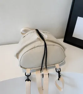 Detailopname van crèmekleurige canvas rugzak met zijstructuur en verstelbare riemen