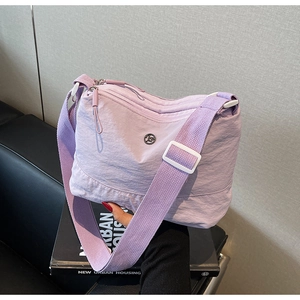 Detail of lavender nylon crossbody bag with double top zippers and round metal logo