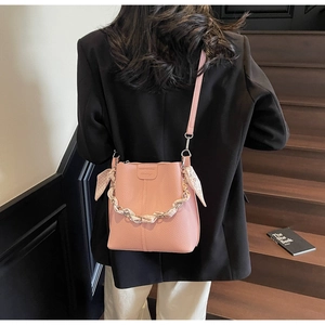 Pink bucket bag with lychee texture leather and floral scarf wrap on the handle