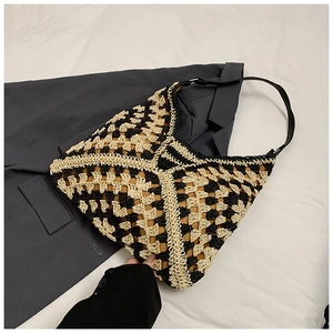 Detail of hand-woven checkerboard pattern and black adjustable leather strap on beach bag