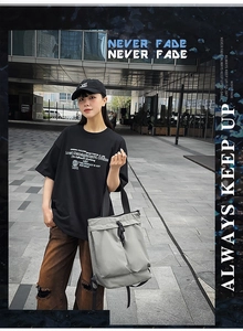 Gros plan d'un sac cabas en nylon gris avec boucles noires dans un cadre urbain moderne