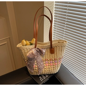 Detail of woven straw tote bag with pink rope texture and paisley scarf ornament