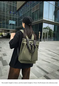 Détail d'un sac fourre-tout en nylon vert armée avec poche avant et sangles noires