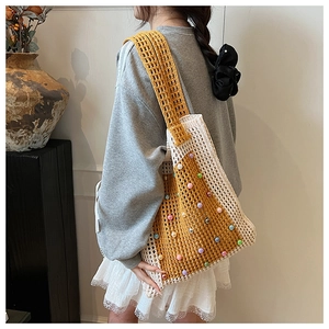 Detail view of handmade crochet shoulder bag with colorful beads and hollow knit design