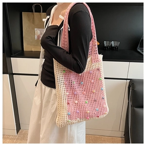 Detail of hand-crocheted shoulder bag with pink white weaving and colorful beads