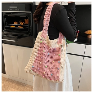 Detail view of handmade crochet shoulder bag with colorful beads and beige pink woven texture