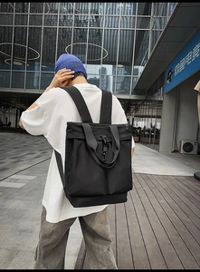 Vue arrière du mannequin portant un sac à dos noir en nylon avec sangles et crochets