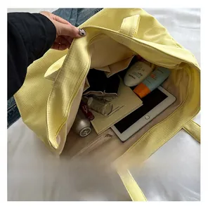 Detail view of the large capacity interior of the yellow tote bag with items