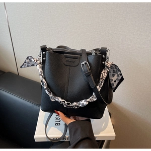 Detail of black lychee grain bucket bag with heart print silk scarf chain handle