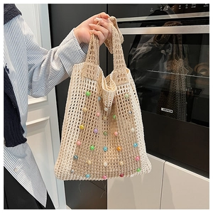 Detail of beige crochet tote bag with colorful faux pearls and diamond mesh pattern
