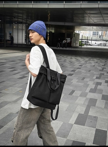 Détail d'un sac cabas en nylon noir avec poches fonctionnelles et clips métalliques
