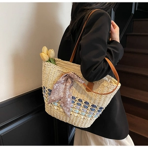 Detail of straw tote bag with blue gradient weave and brown patterned silk scarf on a strap
