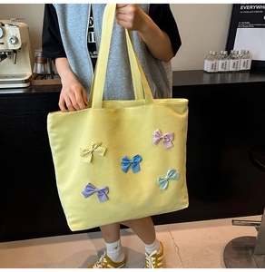 Detail of yellow waffle tote bag with colorful polka dot bows in a cafe setting