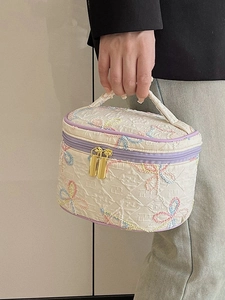 Gesteppte beige Kosmetiktasche mit pastellfarbener Stickerei und lila Rand für Reisen