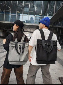 Vue arrière de mannequins portant de grands sacs à dos en nylon gris et noirs