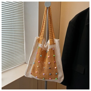 Detail of hollow knit shoulder bag featuring colorful beads and yellow contrast design
