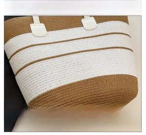 Gros plan d'un sac de plage tressé bicolore montrant les détails de texture et couture