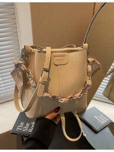 Elegant beige bucket bag with lychee texture and heart print silk scarf handle detail