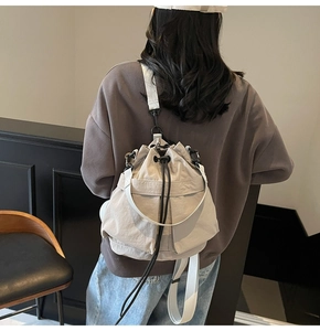 Achteraanzicht van een lichtbeige canvas bucketbag gedragen als casual schoudertas