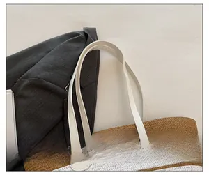 Vue détaillée du tissage tricolore et de la bandoulière en cuir blanc du sac de plage
