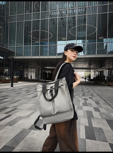 Photo en extérieur d'un grand sac à dos en nylon vert grisâtre au style urbain