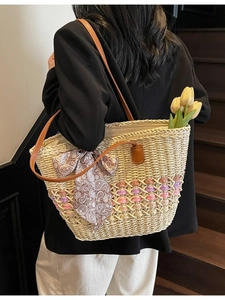 Women's woven straw beach tote bag with leather handles and colorful striped accents