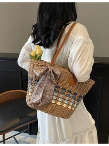 Women's straw woven tote bag with colorful stripes and paisley bow for beach travel