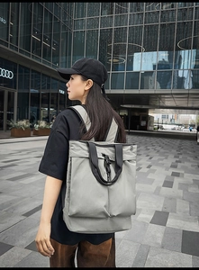 Détail d'un sac à dos gris en nylon avec poches avant et texture de tissu dense