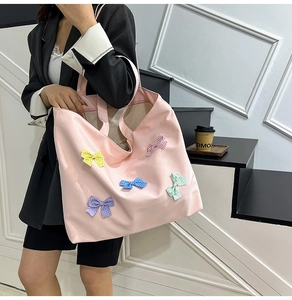 Pink canvas tote bag with colorful polka dot bows shown on a minimalist staircase