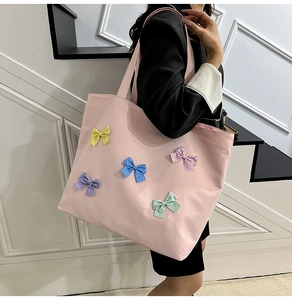 Pink canvas tote bag featuring colorful polka dot 3D bowknot details on the side view