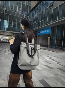 Détail d'un sac à dos fourre-tout en nylon gris clair avec poignées noires en décor urbain