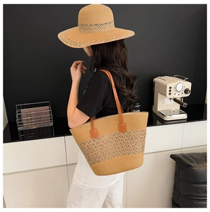 Primer plano del bolso de paja con asas de cuero y sombrero de sol tejido a juego