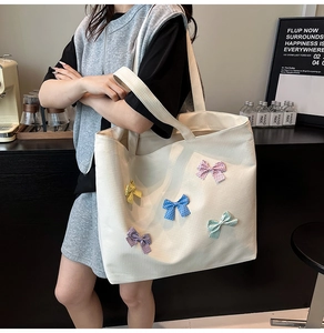 Detail of canvas tote bag with colorful polka dot bows and textured grid pattern
