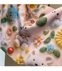 Detail of soft fabric showing 3D crochet patterns with bears and flowers on the tote bag