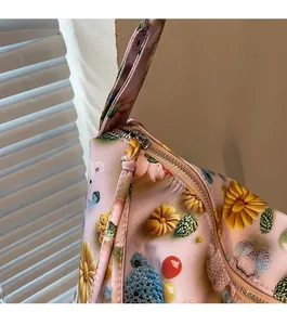 Detail of smooth metal zipper and floral daisy pattern on the pink shoulder tote bag