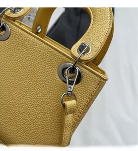 Detailed macro view of yellow litchi pattern leather bag with polished silver hardware