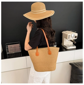 Detalle de bolso tote de paja tejida con asas naranjas resistentes para la playa y verano
