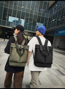 Détail de grands sacs à dos en nylon vert olive et noir avec fonctions utilitaires extérieures