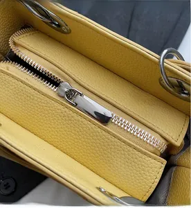 Macro view of bright yellow lychee leather bag with smooth silver metal zipper and hardware