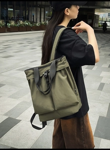 Sac à dos fourre-tout en nylon vert armée avec boucles avant dans un décor urbain extérieur