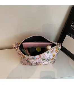 Detail view of pink cartoon tote bag showing spacious interior with tablet and cosmetics