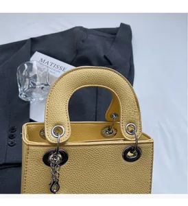 Macro shot of yellow lychee texture leather handbag with silver metallic handle rings