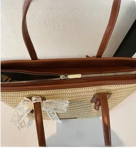 Détail de la fermeture éclair et du nœud en dentelle sur le sac de plage en paille tissée